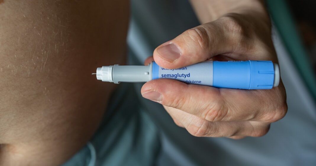 Ilustración de un médico revisando información de un fármaco en una tablet, con símbolos de alerta y salud de fondo.