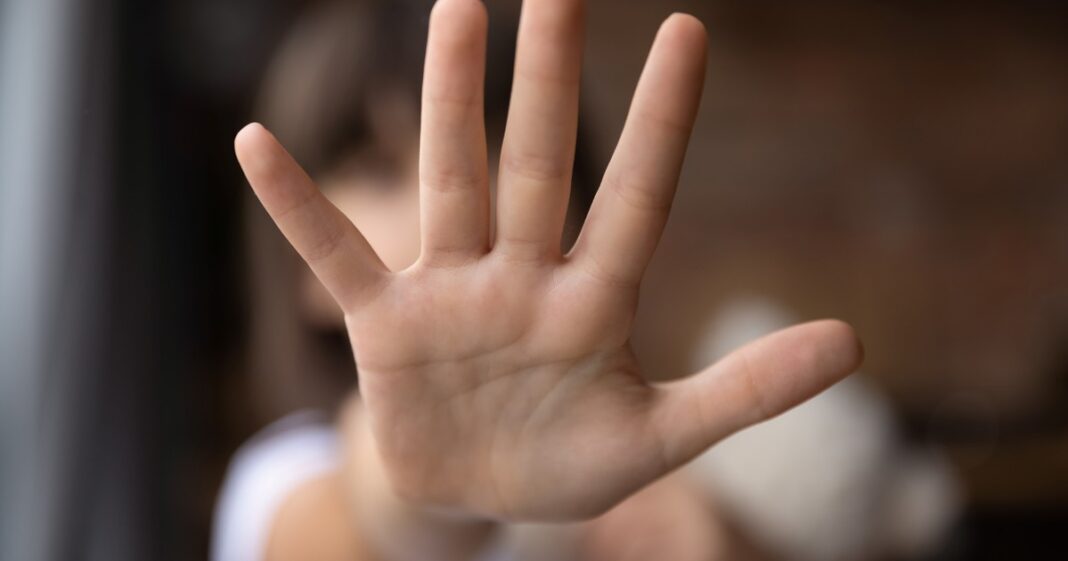 Adolescente mirando un teléfono celular en un aula escolar