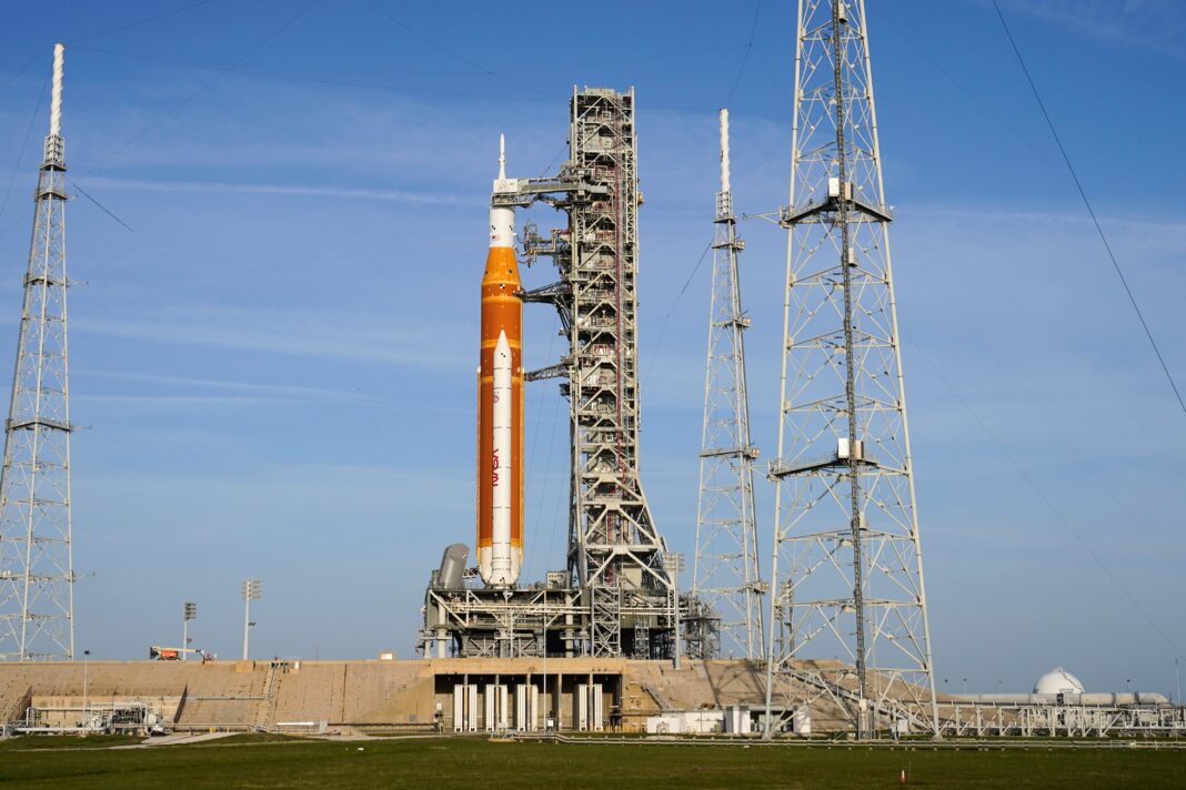Ilustración del cohete SLS de la NASA en la plataforma de lanzamiento para la misión Artemis II.