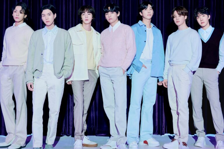 Integrantes de la banda BTS en el escenario durante una presentación.