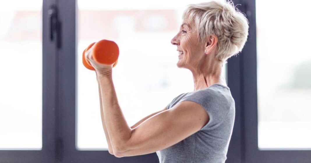 Persona mayor realizando ejercicios suaves de fuerza para los brazos en su hogar