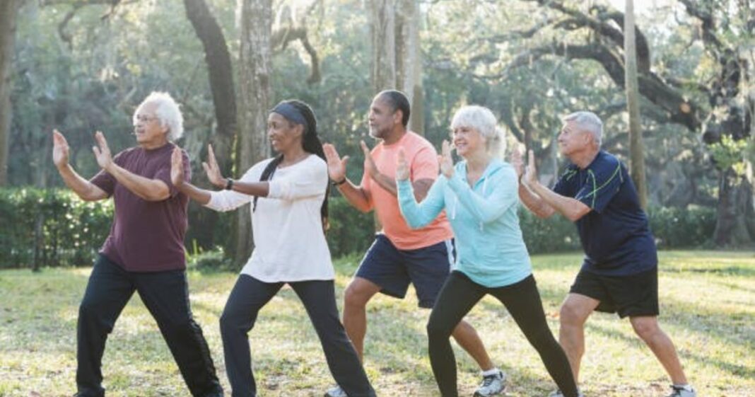 Adulto mayor realizando ejercicios de Tai Chi en un parque
