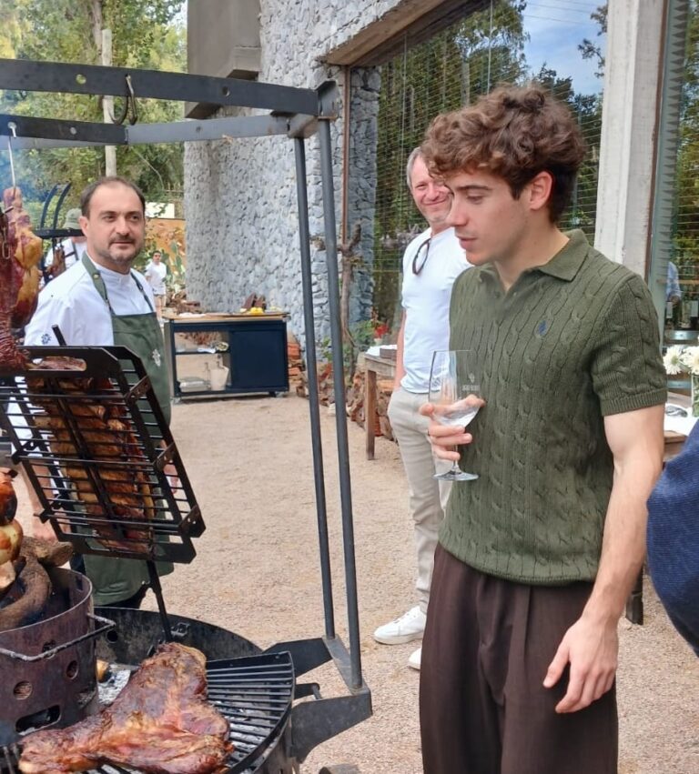 Franco Colapinto con delantal condimentando un asado en Estancia Vigil, Cardales
