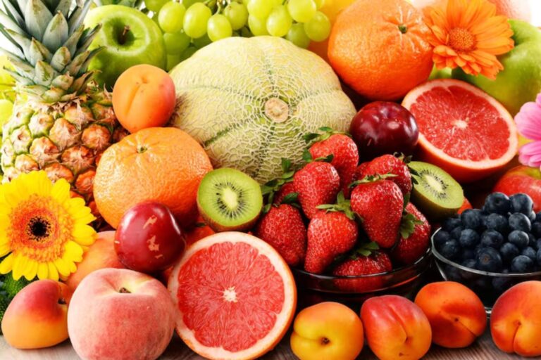 Variedad de frutas frescas sobre una mesa, incluyendo frutos rojos, cítricos y otras recomendadas por especialistas.
