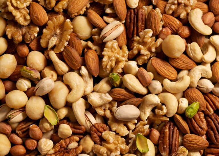 Variedad de frutos secos como nueces, almendras y avellanas en un cuenco de madera.