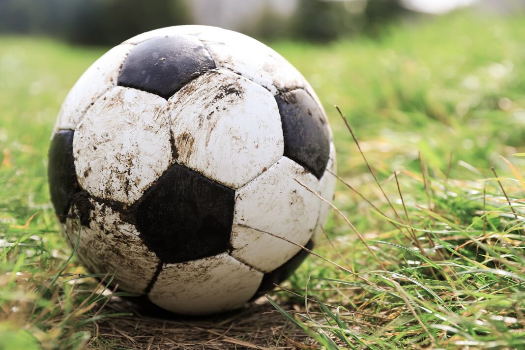 Grupo de amigos posando antes de un partido de fútbol amateur en una cancha de Buenos Aires.