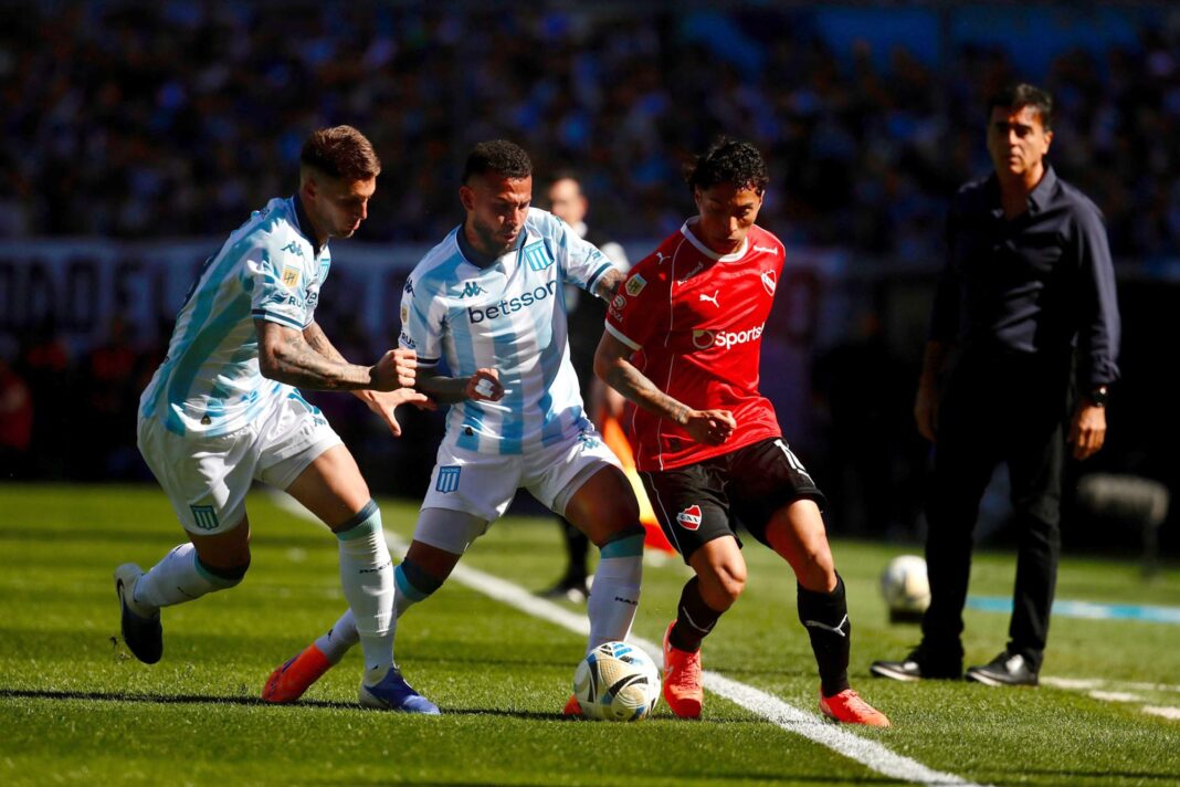 Los escudos de Independiente y Racing, separados por un balón de fútbol, representando el clásico de Avellaneda.