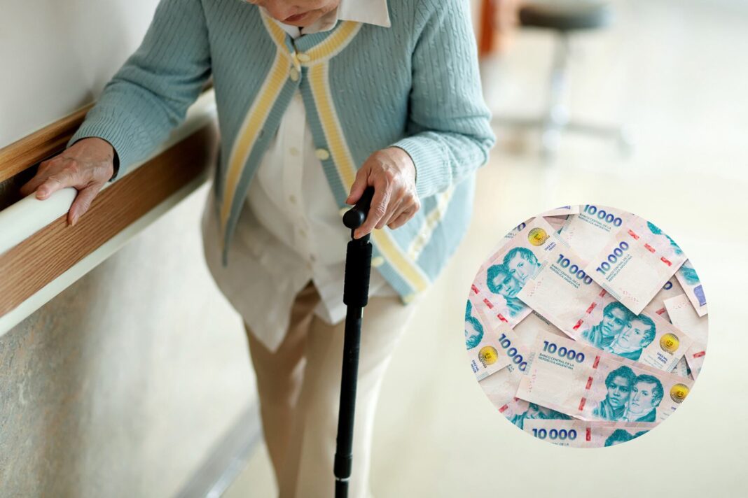 Persona mayor con calculadora y documentos, representando el cálculo de la jubilación mínima en Argentina