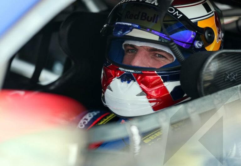 Max Verstappen con el casco de piloto, posiblemente junto a un automóvil de competición.