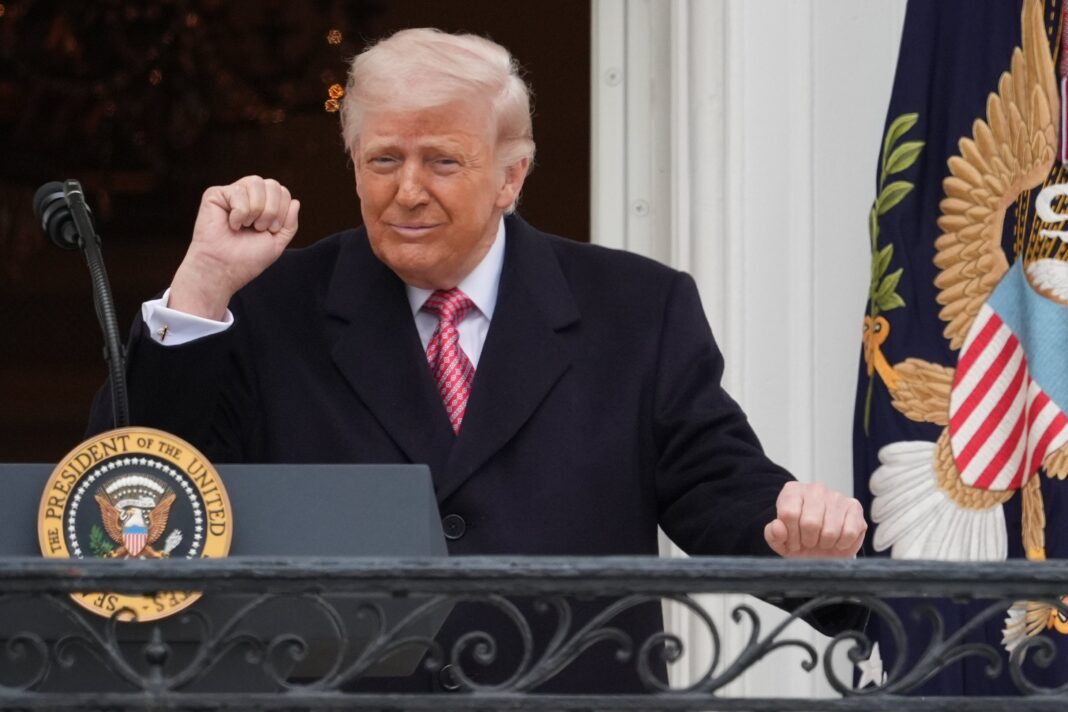 Donald Trump hablando desde un podio, con banderas de Estados Unidos de fondo.