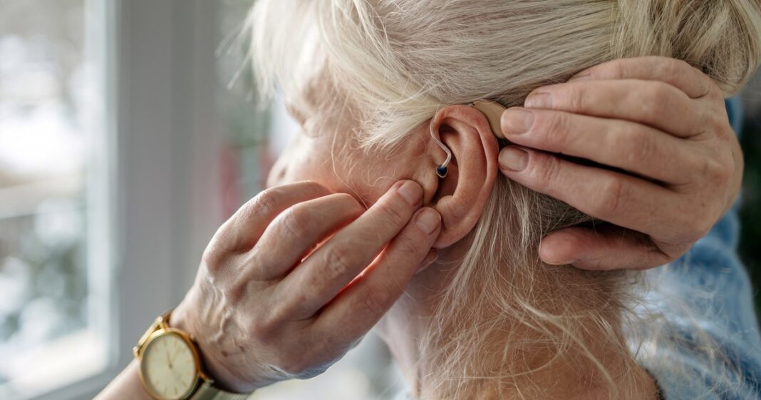 Persona mayor usando audífonos, cuidando su salud auditiva y cerebral