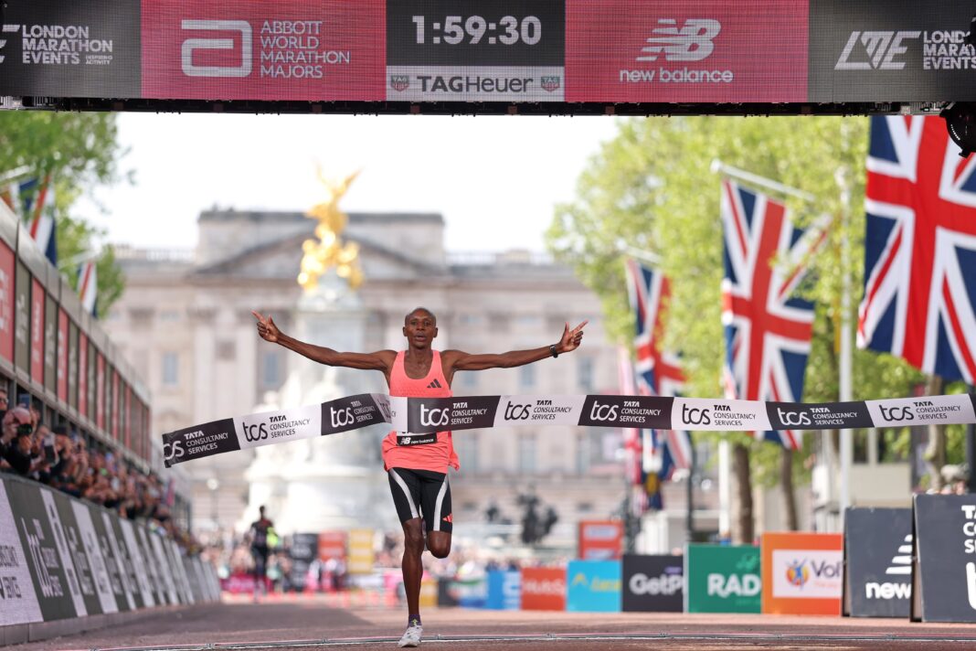 Sabastian Sawe cruzando la meta de la maratón de Londres 2026 con el cronómetro marcando 1h59m30s