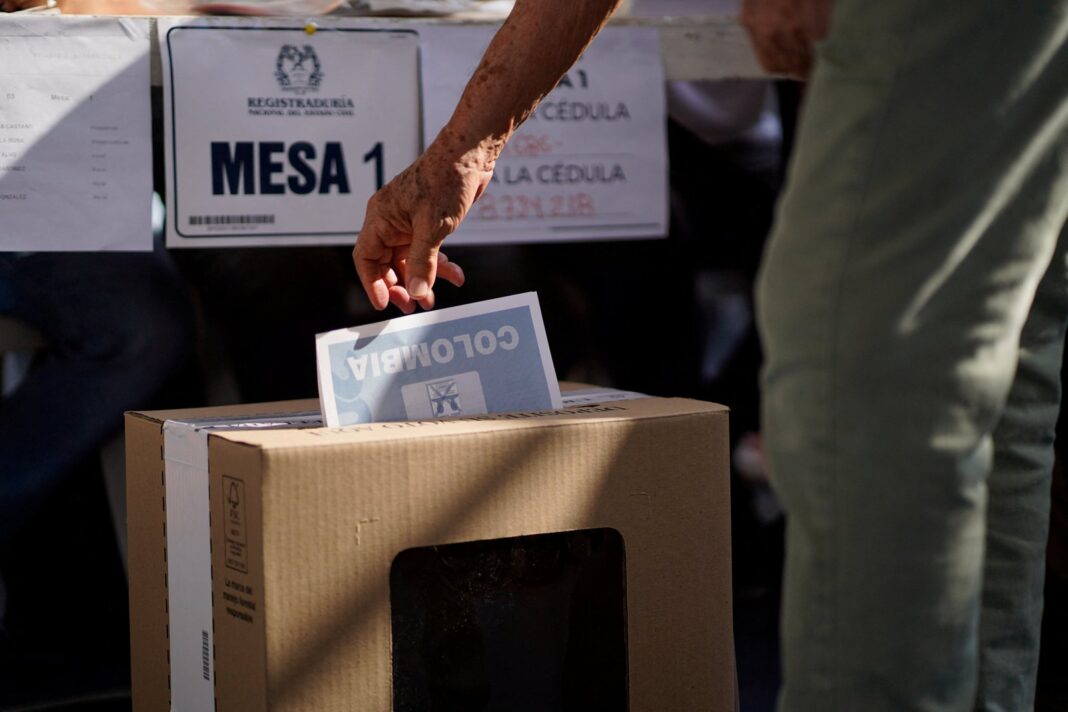 Urnas electorales y votantes en fila durante las elecciones presidenciales de Colombia