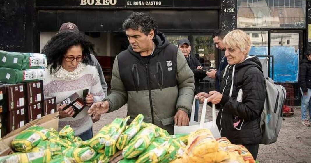 Fila de personas frente al gimnasio de Jorge Castro en Temperley esperando para retirar alimentos