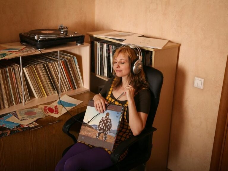 Persona escuchando música con auriculares, con expresión reflexiva