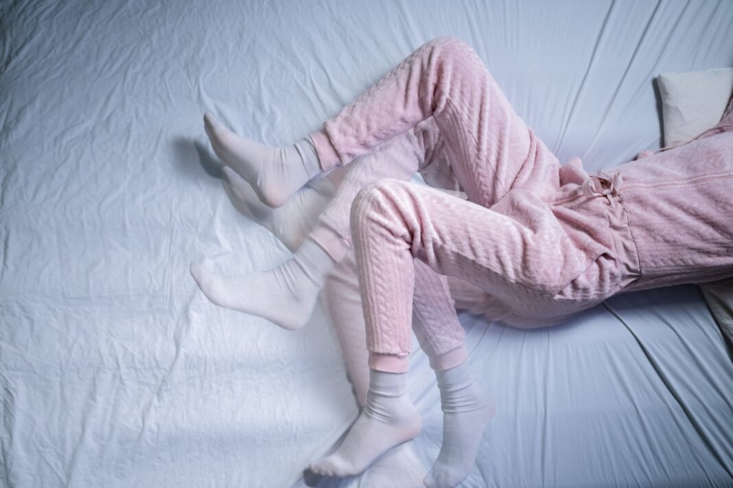 Persona masajeándose las piernas para aliviar el síndrome de piernas inquietas