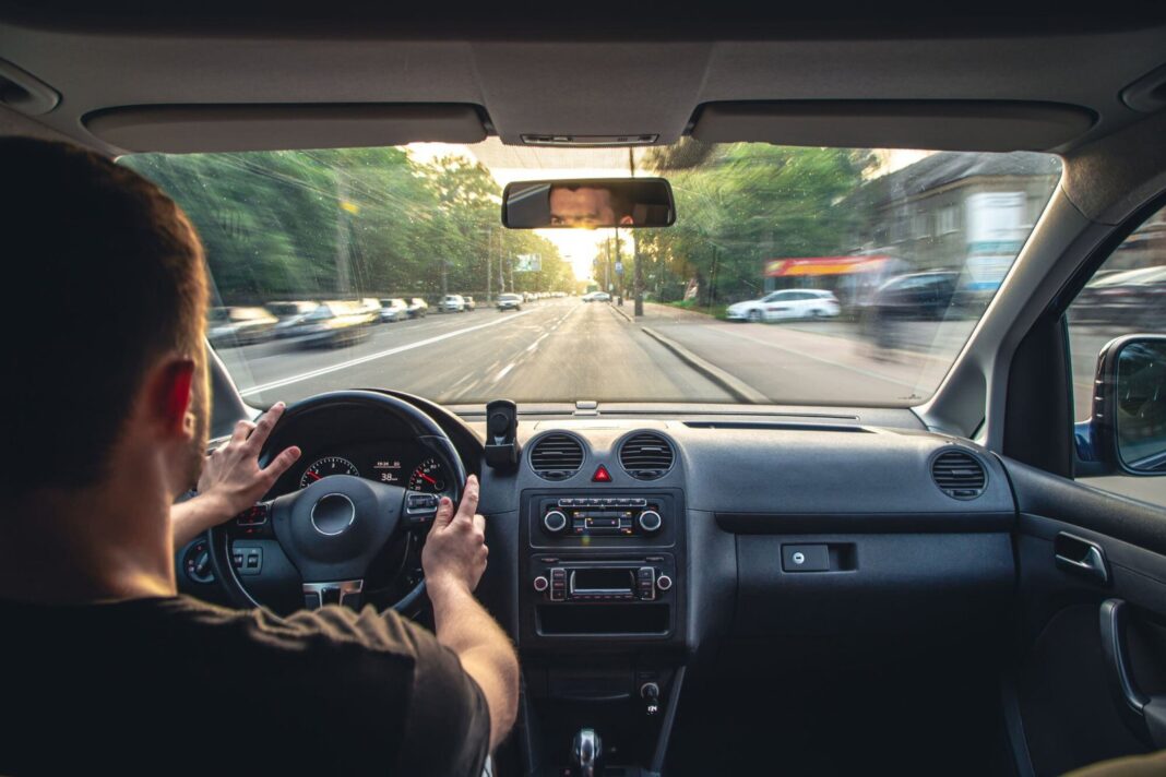 Ilustración de la técnica Dutch Reach para abrir la puerta del auto con la mano derecha mientras se gira el cuerpo para mirar hacia atrás