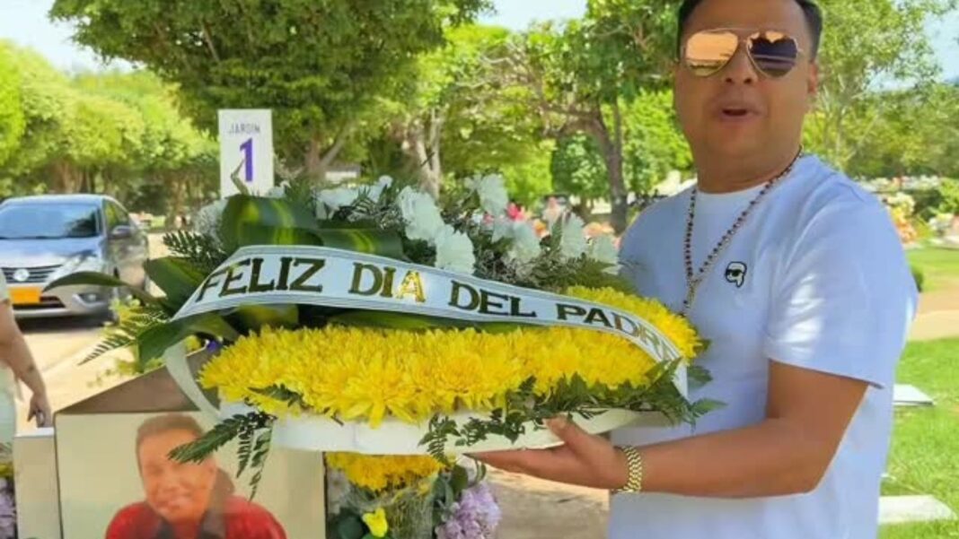 Rafael Santos junto a la tumba de Diomedes Díaz con ofrenda floral y acordeón