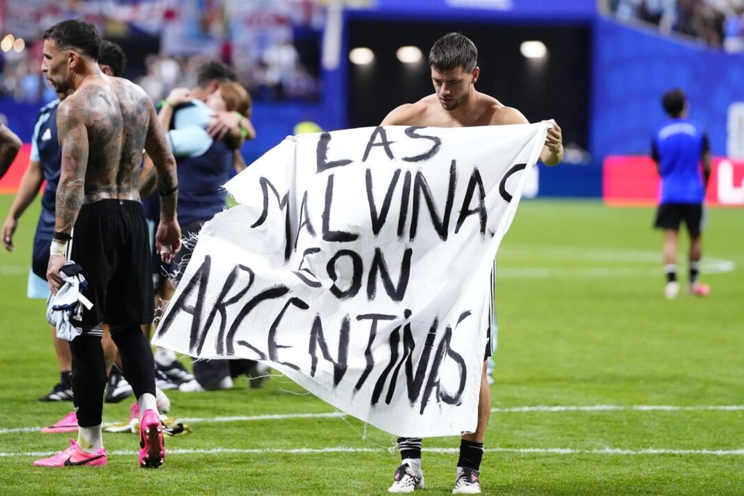 Jugadores de la selección argentina sostienen pancarta con texto Las Malvinas son argentinas tras partido