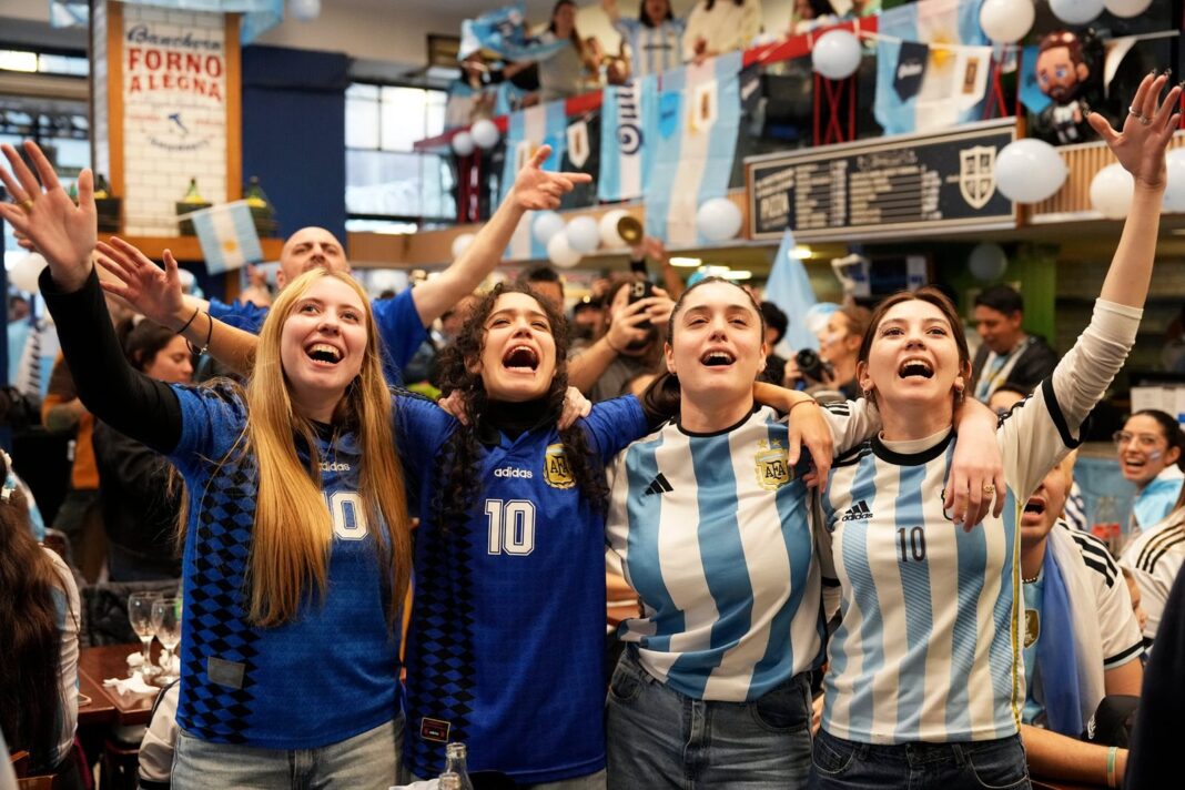 Hinchas argentinos mirando un partido de fútbol en una pantalla