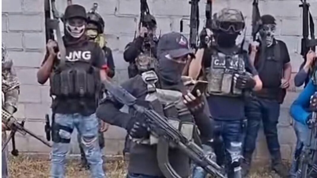 Hombres encapuchados armados con rifles AK y chalecos tácticos con siglas del CJNG en un video