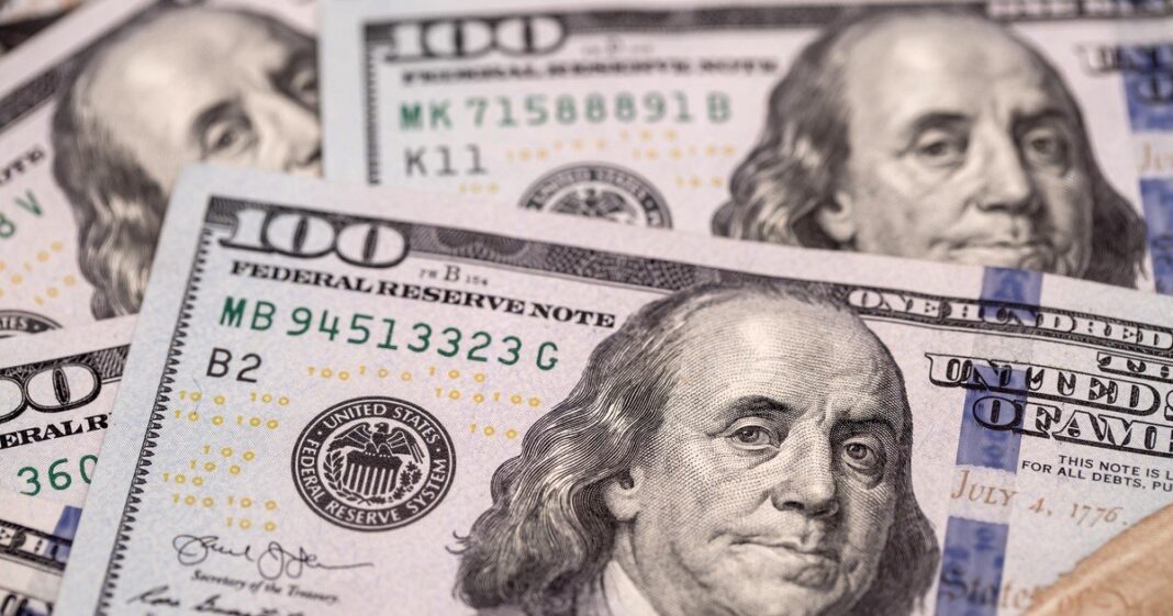 Billetes de dólar y monedas de quetzal guatemalteco