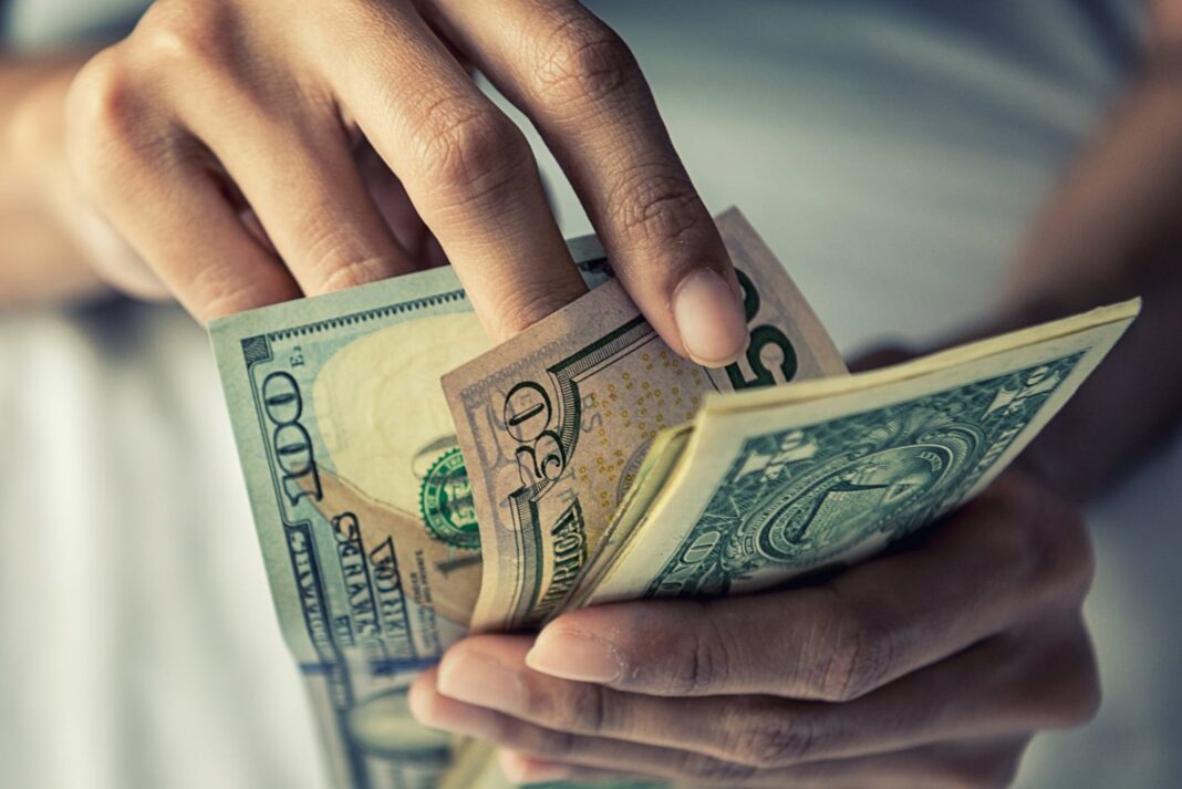 Billetes de dólar y de peso argentino sobre una mesa