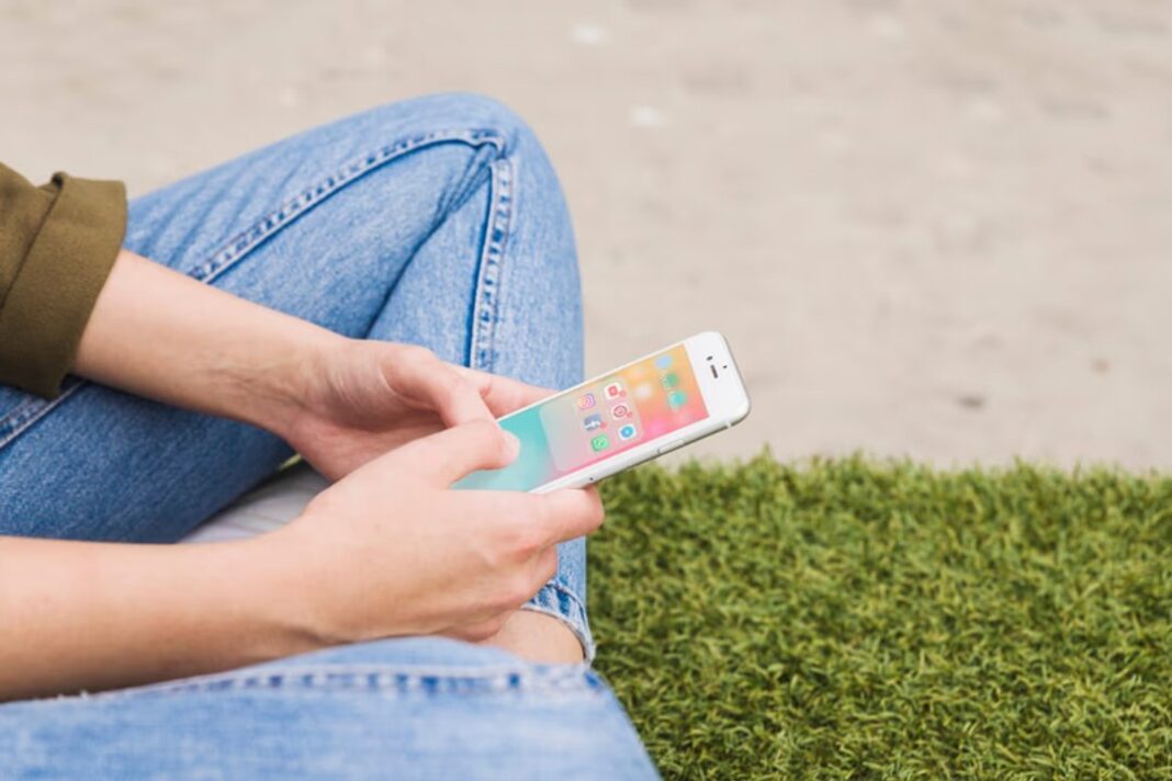 Ilustración de una persona joven usando un teléfono móvil con aplicaciones de redes sociales