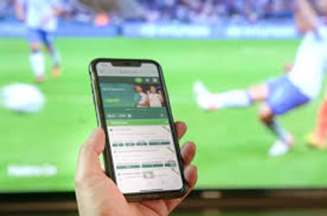 Persona utilizando una plataforma de apuestas en línea en un dispositivo móvil