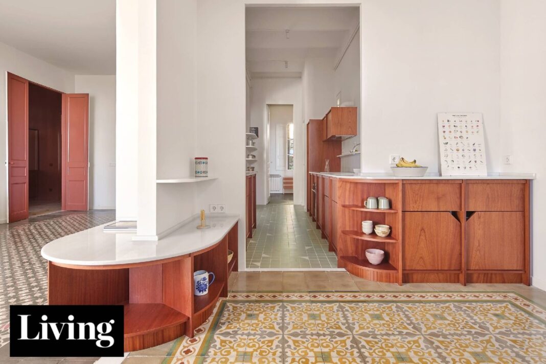 Interior de un departamento modernista reformado en Barcelona con mobiliario de madera oscura y terminaciones redondeadas