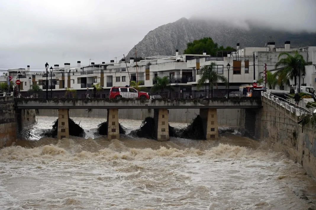 Calle inundada por la tormenta Adam en Valencia, con vehículos arrastrados por el agua